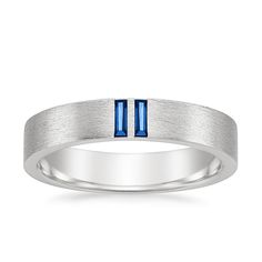 a white gold wedding band with blue sapphire in the center and two diamonds on each side