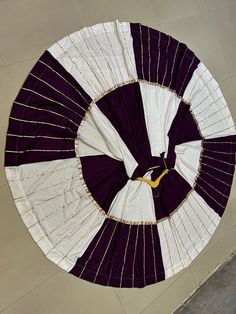 a large purple and white fan sitting on top of a floor next to a wall