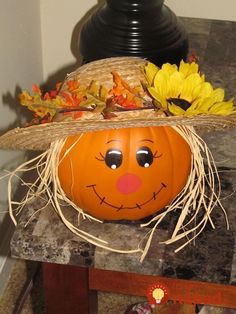 a pumpkin with a scarecrow's hat and sunflowers sitting on top of it