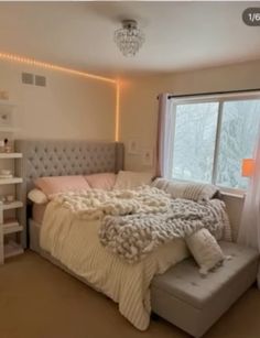 a bedroom with a large bed and lots of lights on the windows sill above it