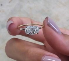 a close up of a person holding a ring with a diamond on the middle finger