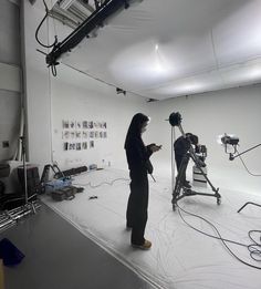 a woman standing in front of a camera on top of a white floor