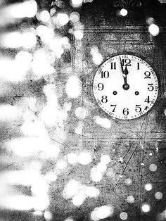 a black and white photo of a clock with rain drops on the window sill