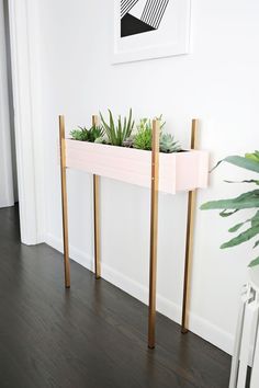 a planter with succulents and plants in it on a wooden stand