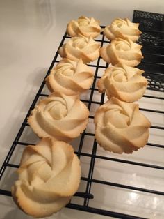 several cupcakes on a cooling rack with frosting in the shape of roses