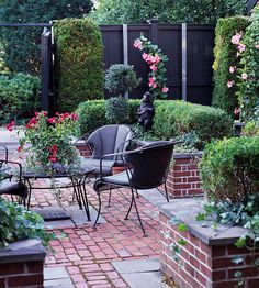 an outdoor patio with chairs and tables surrounded by plants