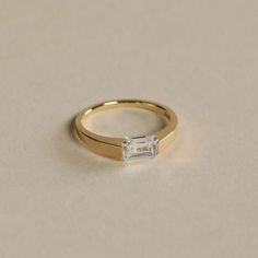 a gold ring with a baguette cut diamond