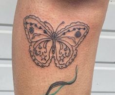 a tattoo on the leg of a woman with a butterfly