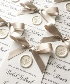 the wedding stationery is laid out on top of each other with ribbons and buttons