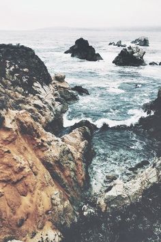 an ocean view with rocks in the foreground