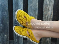 a woman's legs with yellow crochet slippers on top of them