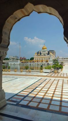 an archway leading to a building with a golden dome in the middle and other buildings behind it