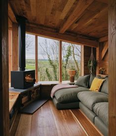 a living room filled with furniture and a fire place in front of a window that looks out onto the countryside