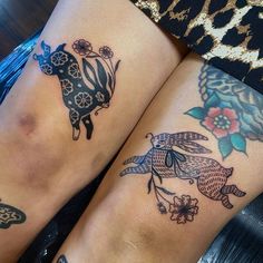 two women with tattoos on their legs sitting next to each other