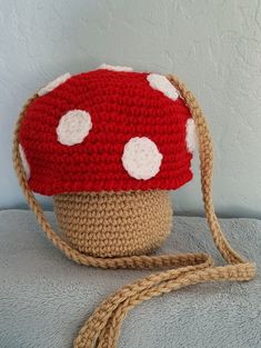 a crocheted mushroom hat with white dots on it