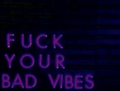 a neon sign that says, f k your bad vibes