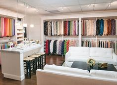 the interior of a clothing store with lots of colorful scarves