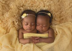 two babies are sleeping on a yellow blanket with their eyes closed and one is holding the other's head