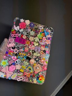 a cell phone case covered in lots of different types of stickers and buttons on it