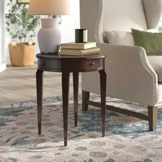 a living room with a chair, table and lamp in it's centerpiece