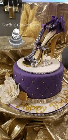 a purple and gold birthday cake with high heels on top