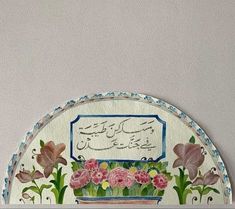 a painting on the wall with flowers and arabic writing