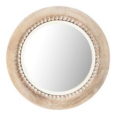 a round mirror with beaded trim around the edges and an oval wooden frame, on a white background