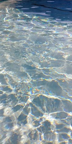 an empty swimming pool with clear water and sun reflecting off the surface on the bottom