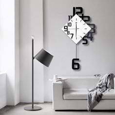 a living room with a white couch and black clock on the wall next to it