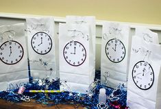 four paper bags with clocks and streamers on them