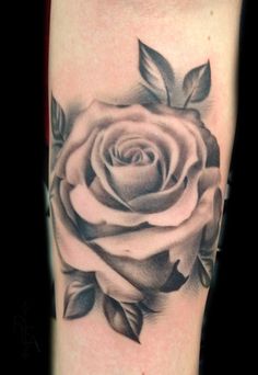 a black and white rose tattoo on the leg