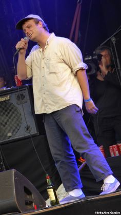 a man standing on top of a stage holding a microphone