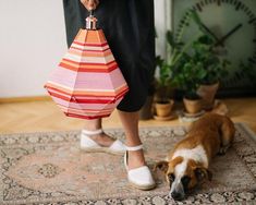 a dog laying on top of a rug next to a woman's feet and purse