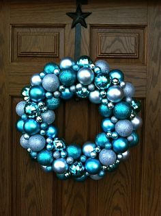 a blue and silver christmas ornament wreath on a door