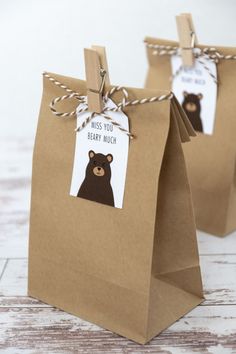 two brown paper bags with tags on them that say miss you baby much and bear much