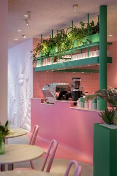 a pink and green restaurant with plants on the shelves