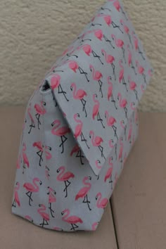 a pink flamingo print tie sitting on top of a wooden floor next to a wall