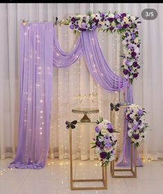 the wedding arch is decorated with purple and white flowers, along with other floral arrangements