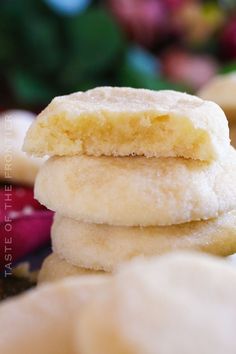 three sugar cookies stacked on top of each other with flowers in the backgroud