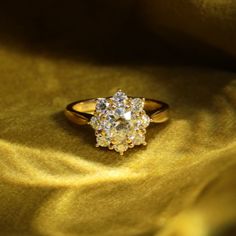 a diamond ring sitting on top of a yellow cloth