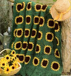 a blanket that has sunflowers on it next to a basket with yellow flowers