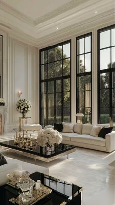 a living room filled with lots of furniture and large windowed windows next to each other