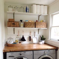 a washer and dryer in a small room with open shelving above them