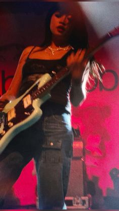 a woman playing an electric guitar on stage