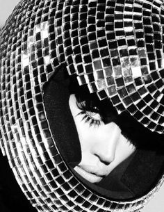 a woman's face is peeking out from behind a mesh covered hat with her eyes closed