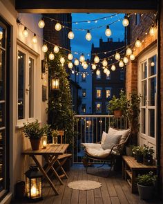 a balcony with lights strung over it and some chairs on the porch next to potted plants