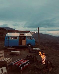 a camper van parked next to a fire pit