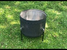 a large metal pot sitting on top of a lush green field