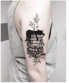 a woman with a cat and books tattoo on her arm