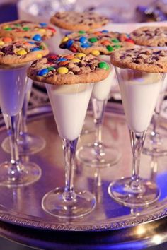 three glasses filled with desserts sitting on top of a metal tray next to each other